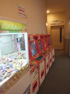 un juego de pinball en una tienda con una fila de máquinas en Natural Onsen Hostel Hidamari no Yu en Takayama
