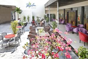 a restaurant with purple chairs and tables and flowers at Bamboo Green Riverside Hotel in Danang