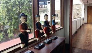 a group of wooden statues sitting in a window at Antonio's Pension House in Dipolog