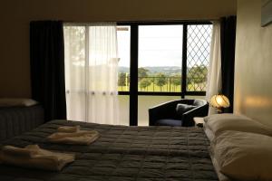 a bedroom with a bed and a large window at Drury Motor Lodge in Drury
