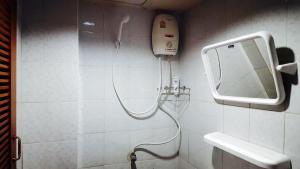 una doccia in un bagno con uno specchio di Lucky Dorm a Phi Phi Don