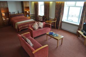 um quarto de hotel com uma cama, um sofá e uma mesa em Expanse Hotel em Bridlington