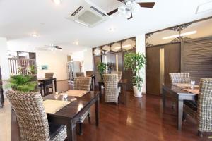 a restaurant with wooden tables and chairs at Kerama Terrace in Tokashiki