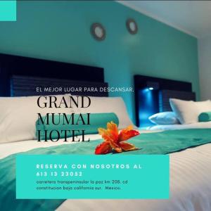 un póster para un gran hotel Mumbai con una flor en una cama en Hotel Mumai, en Ciudad Constitución