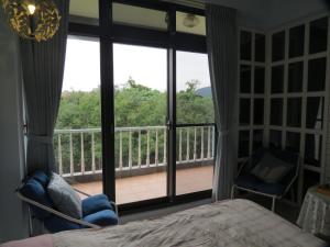 a bedroom with a large window with a view of a balcony at Beetles Forest in Jiaoxi