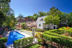 een huis met een zwembad in een tuin bij Alderly Apartment 6, Little Cove in Noosa Heads