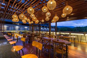 a restaurant with wooden tables and chairs and lights at Plataran Heritage Borobudur Hotel in Borobudur