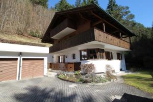 a house with a wooden roof and a garage at Chalet Adriana in Garmisch-Partenkirchen