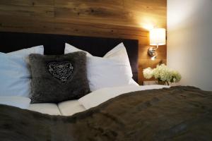 um quarto com uma cama grande e almofadas brancas em alpin penthouse em Piesendorf