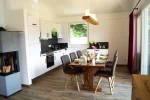 a kitchen with a wooden table and chairs in a kitchen at alpin penthouse in Piesendorf