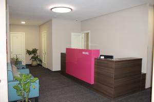 een kantoor met een receptie en een roze muur bij Wellotel Yuzhne in Yuzhne