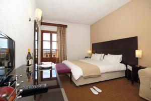 a hotel room with a large bed and a desk at Boutique Hotel Parnassia in Arachova +65 photos