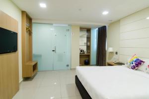 a bedroom with a bed and a walk in shower at Mornington Hotel Sitiawan in Sitiawan