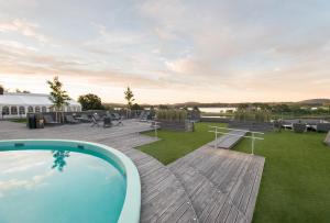 a backyard with a pool and picnic tables and benches at Quality Hotel Skjærgården in Langesund