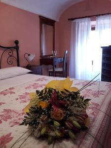 a bouquet of flowers on a bed in a bedroom at La Casa dei Nonni B&B in Scanno