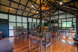 a dining room with wooden tables and chairs at Hillside - Nature Lifestyle Lodge in Luang Prabang