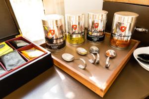 a wooden tray with spoons and cups on a counter at Hôtel Hélios in Juan-les-Pins
