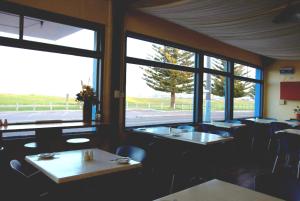 
a dining room table with chairs and a window at Esperance Beachfront Resort in Esperance
