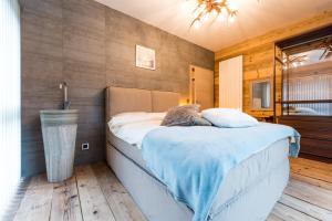 a bedroom with a bed with a blue blanket at WOO® Loft Resort in Fiesch