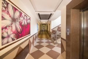 纳特杜瓦拉Hotel Vaikunth By Adamo的走廊上设有 ⁇ 形地板和墙上的艺术品