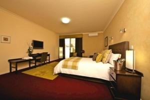 a bedroom with a large bed and a desk and a desk at The Inn Mahogany Creek in Mahogany Creek