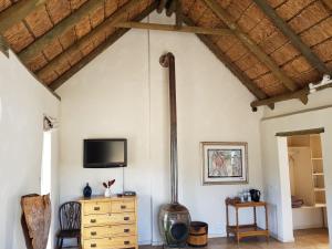 a living room with a tv and a wooden ceiling at Karoo 1 Hotel Village in De Doorns