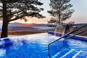 a swimming pool with a chair and a sunset at Catalonia Reina Victoria in Ronda