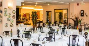 una sala banchetti con tavoli e sedie bianchi di Hotel Antares a Cattolica