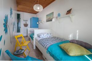 1 dormitorio con 2 camas y silla amarilla en Stonehouse Katarina, en Igrane