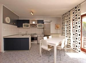 een keuken met een witte tafel en witte stoelen bij Apartments Dusanka 799 in Fažana