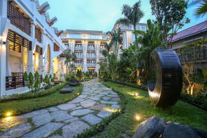 un patio de un hotel con un gran edificio en The Night Hotel, en Siem Reap
