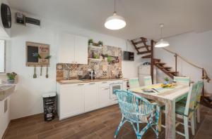 a kitchen with a table and chairs in a room at Stonehouse Katarina in Igrane