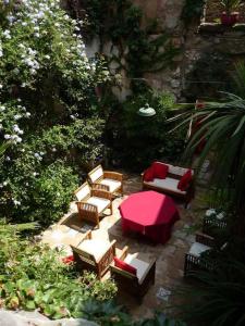 a patio with couches and a red table and chairs at Maison d'Almes in Adissan