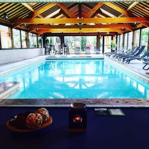 a swimming pool with a plate of food and a candle at Domaine de la Haie des Granges in Ménilles