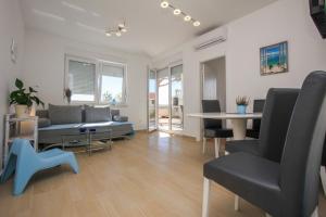 - un salon avec un canapé, une table et des chaises dans l'établissement Apartment BLUE, à Povljana