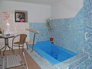 uma banheira azul num quarto com uma mesa em Pension Lípa em Horní Marsov