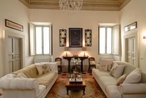 a living room with two couches and a chandelier at Palazzo Sant'Angelo in Spoleto
