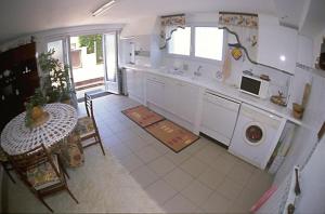 a kitchen with a table and a washing machine in it at L'Hernani in Capbreton