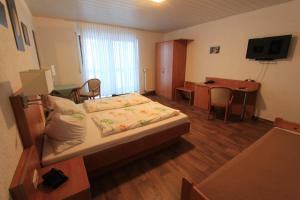 a hotel room with a bed and a desk at Pension Dreiländereck in Birx