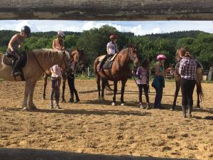 un grupo de gente montando caballos en un campo de tierra en Resort Ohrada, en Vísky