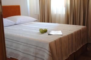 two green apples sitting on a bed with a towel at Royal Apartments in Smederevo