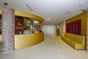 a lobby of a hotel with a yellow counter at Sky Hotel Tirana in Tirana