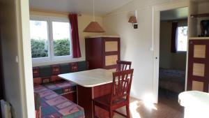 cocina con mesa y silla en una habitación en Camping les Pinasses, en La Chapelle