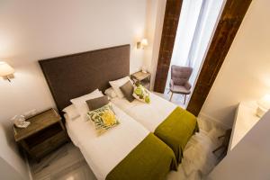カディスにあるElegant Cádizのベッドルーム1室(ベッド1台、椅子、窓付)