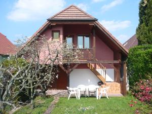 ein Haus mit einem Balkon, einem Tisch und Stühlen in der Unterkunft Gite-Annie in Hunawihr