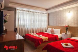 a hotel room with two beds with red sheets at Koniko Hotel in Ho Chi Minh City