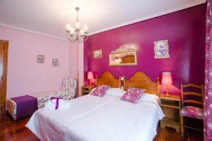 a bedroom with a white bed with purple walls at Posada Rio Cubas in Cubas