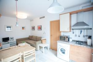 a kitchen and living room with a table and a living room at Apartamento San Bernardo in Seville