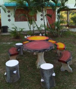 a table and stools in front of a house at Baan Termsuk in Khao Kho