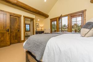 a bedroom with a large bed and large windows at Homestead Cabin 2 in Big Sky